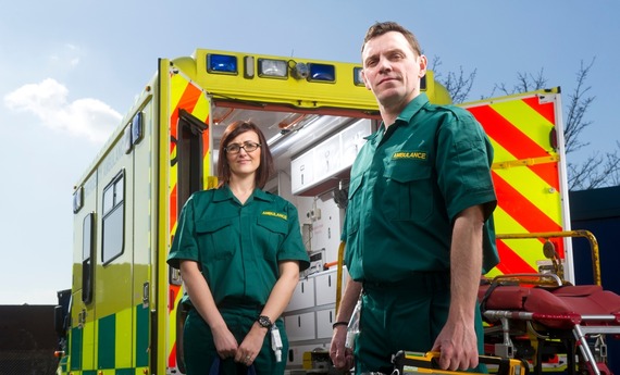 two paramedics in front of an ambulance
