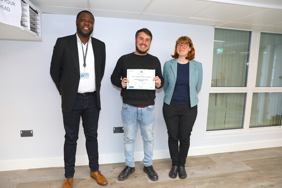 Three people standing holding a certificate on the right is Councillor Dunne