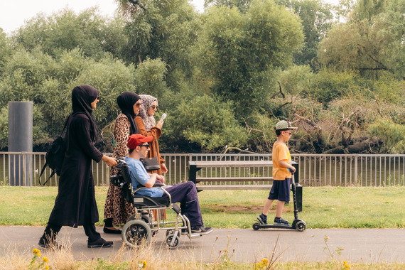 Residents traveling down a road on scooter, wheelchair and walking
