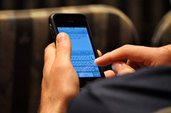 Person's hand typing on their phone (Image courtesy of Joeshoe used under Flickr creative commons