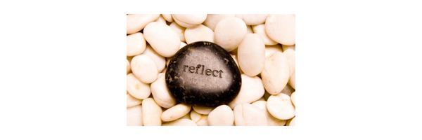 The word "reflect" inscribed on a pebble