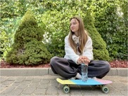 picture of teenage girl sat on skateboard