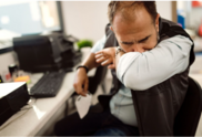 man sneezing into elbow