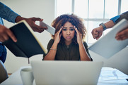 Staff member holding head whilst being surrounded by colleagues 