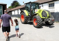 parent and child walking on a farm