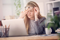 woman at laptop looking stressed