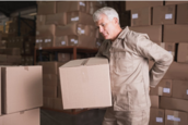 Man holding back whilst carrying boxes