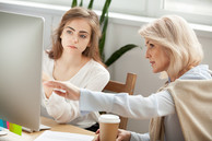 female worker and apprentice on computer