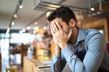 stressed male worker with head in hands