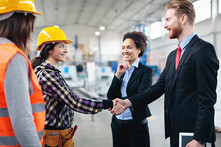 workers meeting inspectors in warehouse