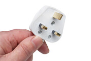 Hand holding three pin plug