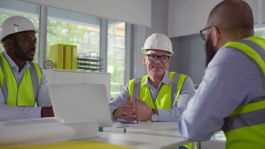 Construction company leader discussing project with engineers in office