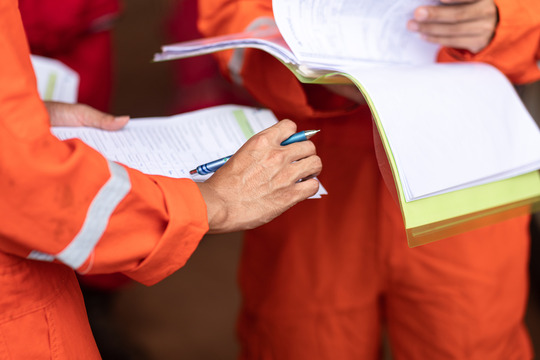 Worker holding report in discussion with group 