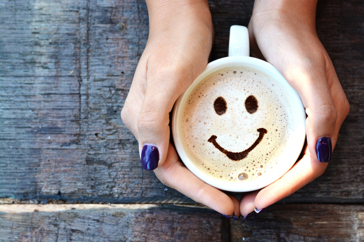 Hands holding mug with happy face