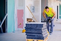 male worker on construction site moving equipment