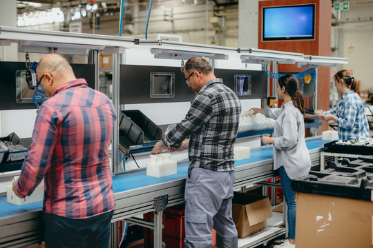 Group of workers working on the production line in factory