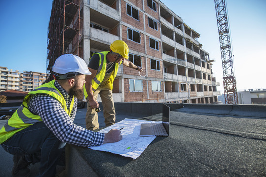 Two staff members wearing safety equipment on building site