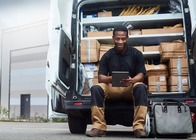 lone delivery driver checking emails in his van