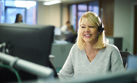 female worker at desk in office wearing phone headset