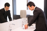 worker washing hands in toilet area