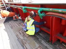 Photo showing invasive survey on Arctic Corsair - shows a marine engineer working on deck.
