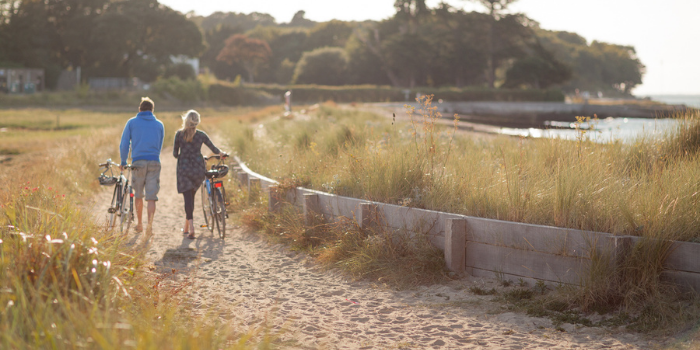 VIOW - couple walking bikes on the beach