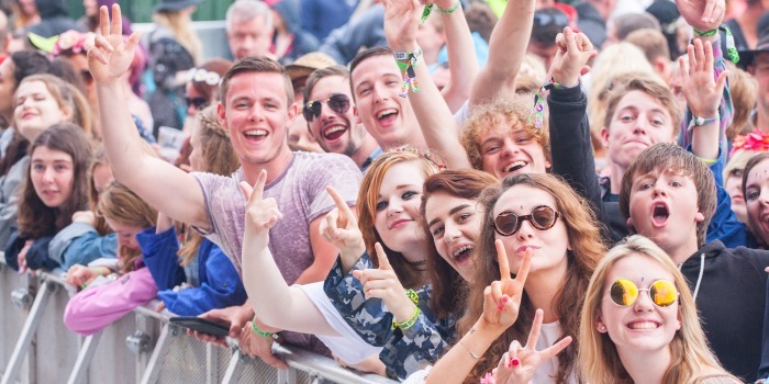 People waving behind a barrier at the Isle of Wight Festival