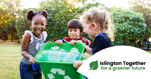 Young children smiling sorting plastic bottles for recycling.
