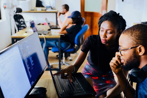 Man and woman in an office environment looking at a computer screen.