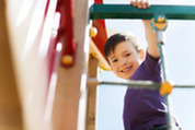 Child smiling and playing on a climbing frame
