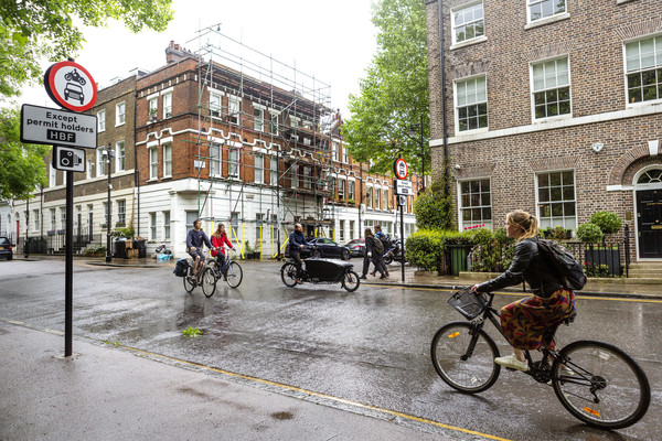 People cycling along Highbury people-friendly street on a rainy day