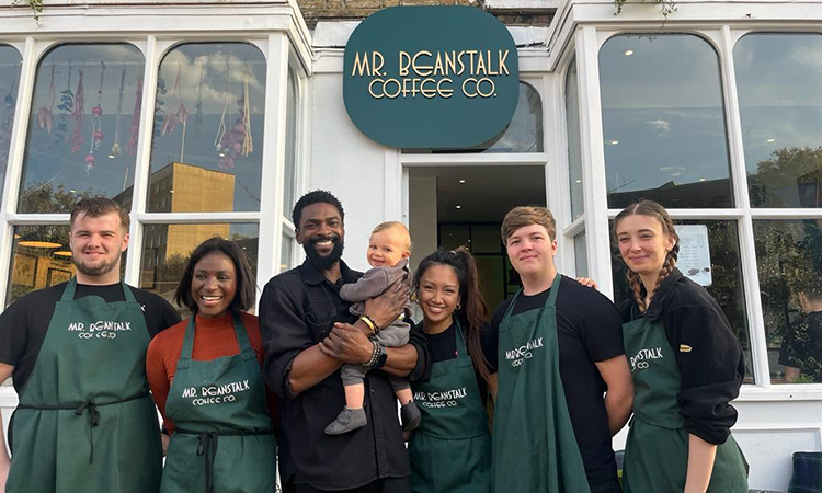 Owner Christian holding his baby, lined up with his staff out the front of Mr Beanstalk Coffee Co cafe