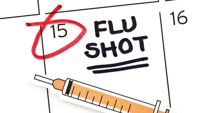 A calendar with the 15 marked on it and a flu injection needle