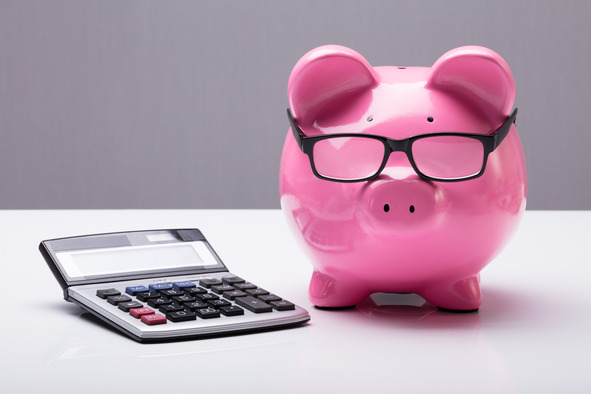piggybank with glasses on its eyes and a calculator