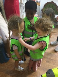 A small group of children wearing high visibility jackets