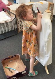 A child dressing a manequin