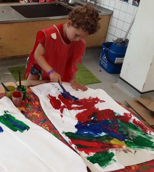 A child painting a large pillow case