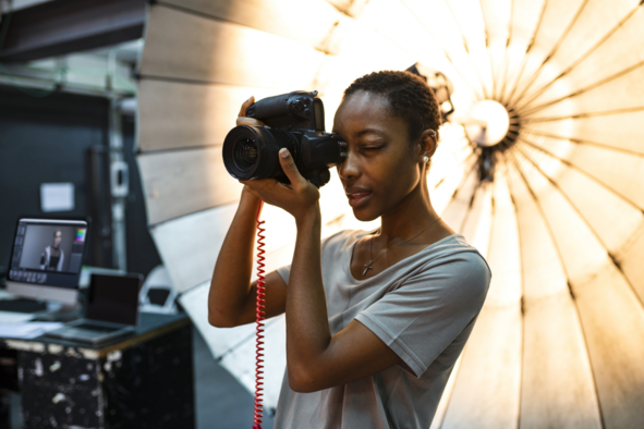 Lady using an expensive camera in a professional looking studio