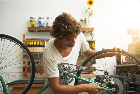 Man smiling whilst repairing his bike