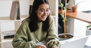 Girl smiling and working on a laptop