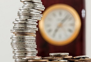 Money stacked up and clock in background