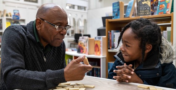 Man and girl play dominos at Brixton Library