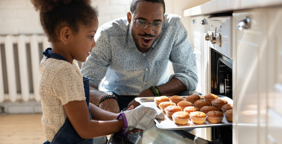 Male carer oversees child baking