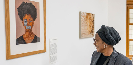 A lady looks at the artwork in the townhall from the 'Memories of our future collection"