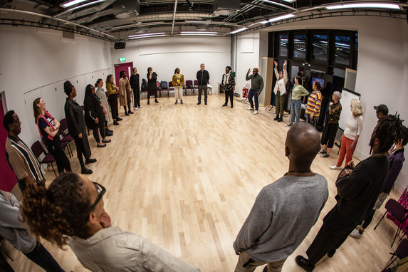 people standing around in a circle part of a workshop