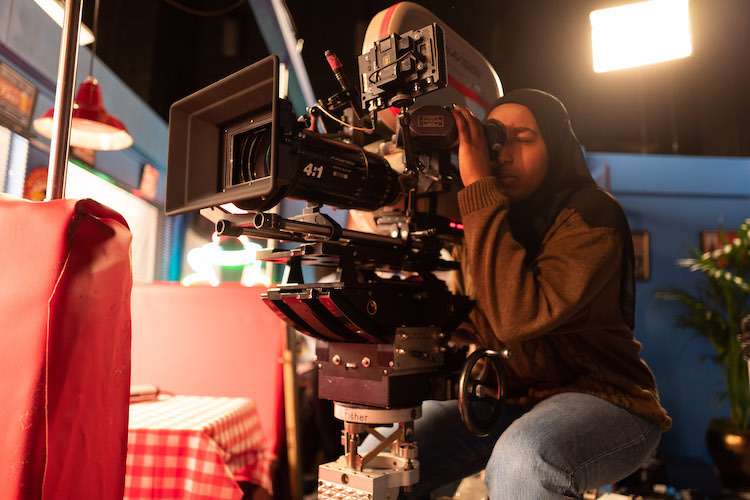 young girl holding a big recording camera 