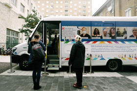 Two people in front of Camden's vaccine bus
