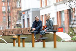 A man and woman sat chatting on a bench