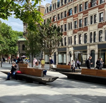 St Giles Circus people sit on new benches 