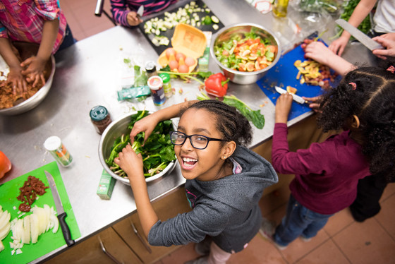 Child looking up to the camera while cooking